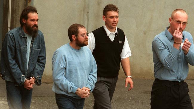 Pictured in June 2000, a security guard, centre, escorts Haydon, left, and convicted serial killers John Justin Bunting, second from left, and Robert Joe Wagner, right, into court during their trial.