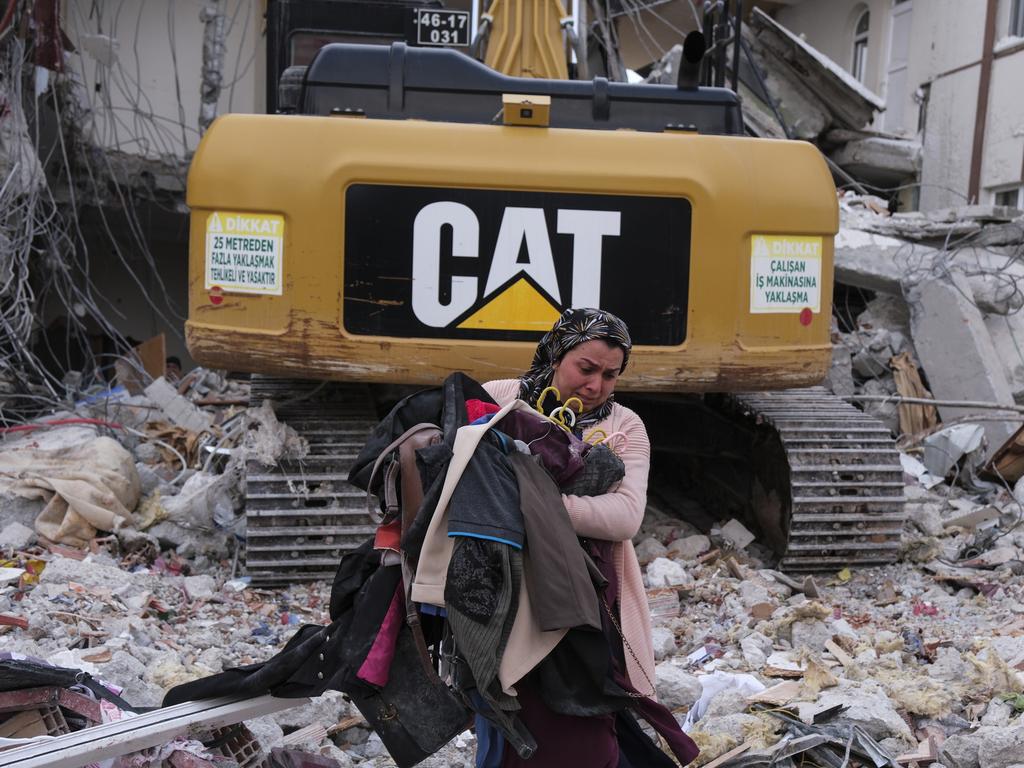 An earthquake survivor carries clothes from the ruins of her home in Gaziantep, Turkey. Picture: Getty Images