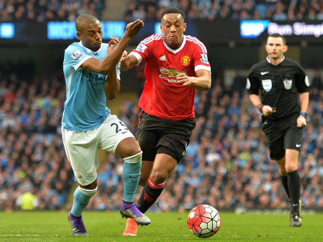 Manchester City's Fernandinho (L) vies with Manchester United's Anthony Martial.