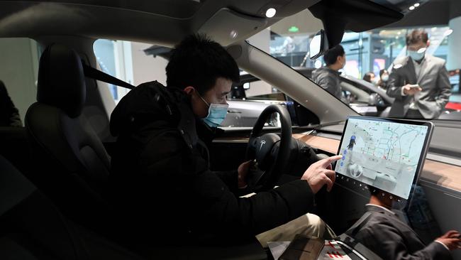 A man checks the dashboard touch screen in a Tesla Model Y car at a showroom in Beijing. Picture: Picture: AFP