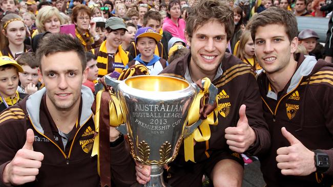 Luke Breust (far right) with (from left) Jack Gunston and Grant Birchall and the 2013 AFL premiership cup.