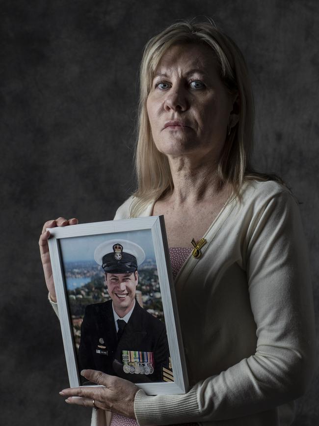 Adelaide mother Julie-Ann Finney holding a portrait of her veteran naval officer son David Finney, who took his own life in 2019.