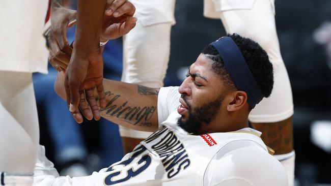 New Orleans Pelicans forward Anthony Davis is helped off the court after clashing with Nikola Jokic.