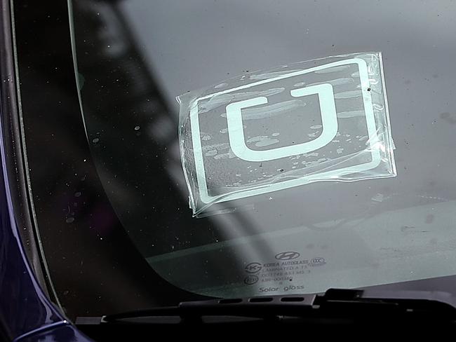 (FILES) In this file photo taken on June 12, 2014 a sticker with the Uber logo is displayed in the window of a car in San Francisco, California.  Waymo and Uber announced an agreement on February 9, 2018 to end the blockbuster trial in which the ridesharing giant was accused of stealing trade secrets from the former Google car unit. The settlement ends a trial between two Silicon Valley rivals in a race to develop self-driving cars after four days of testimony before a federal judge in San Francisco. / AFP PHOTO / GETTY IMAGES NORTH AMERICA / JUSTIN SULLIVAN