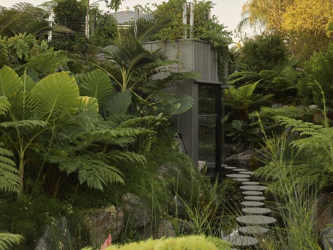 The sleek, glass-walled studio is accessed via a series of lilypads. Picture: Toby Scott