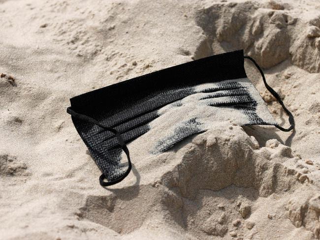 Sand covers a discarded face mask at the beach in Tel Aviv. Israel has more than half of the population fully vaccinated in one of the world's fastest COVID-19 inoculation campaigns. Picture: AFP