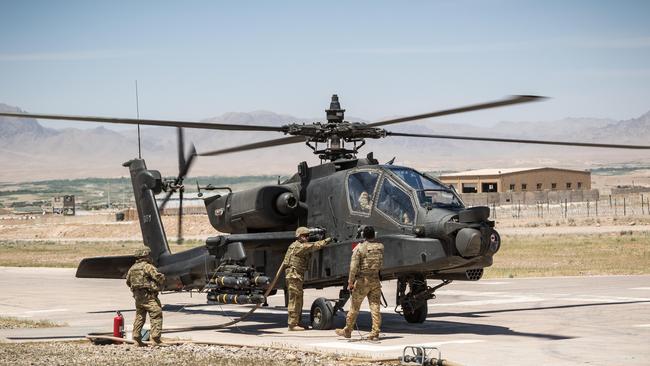 US army soldiers assigned to Task Force Warhawk, 16th Combat Aviation Brigade, 7th Infantry Division, refuel an AH-64 Apache helicopter in Uruzgan Province, Afghanistan. Picture: Alamy