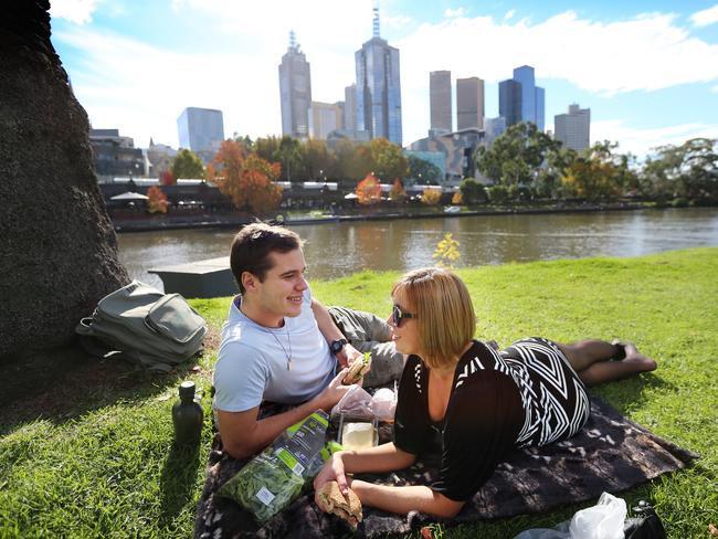 Andrew Wood-Collier and Emma Hall soak up the Melbourne sunshine with a picnic on the Yarra. Picture: Alex Coppel