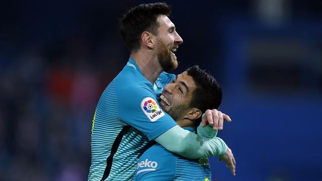 Lionel Messi celebrates with teammate Luis Suarez.