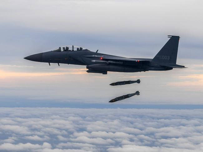 This handout photo taken on October 4, 2022 and provided by the South Korean Defence Ministry in Seoul shows a South Korean Air Force F-15K dropping two joint direct attack munition (JDAM) bombs against a target at the Jikdo shooting field in the Yellow Sea, during a precision bombing drill in response to North Korea firing an Intermediate Range Ballistic Missile over Japan. (Photo by Handout / South Korean Defence Ministry / AFP) / RESTRICTED TO EDITORIAL USE - MANDATORY CREDIT "AFP PHOTO / South Korean Defence Ministry" - NO MARKETING NO ADVERTISING CAMPAIGNS - DISTRIBUTED AS A SERVICE TO CLIENTS