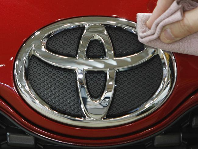 An employee at Toyota Motor Corporation's showroom polishes a Toyota logo on a vehicle in Tokyo, Japan 06/01/2009.