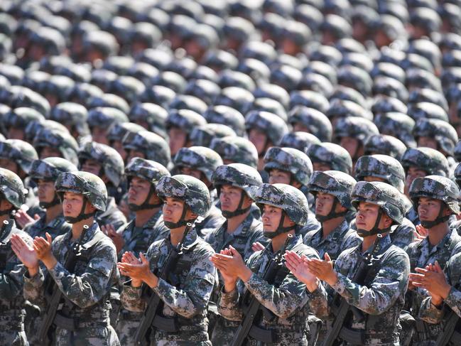 TOPSHOT - Chinese soldiers applaud during a military parade at the Zhurihe training base in China's northern Inner Mongolia region on July 30, 2017. China held a parade of its armed forces on July 30 to mark the 90th anniversary of the People's Liberation Army (PLA) in a display of military might. / AFP PHOTO / STR / China OUT