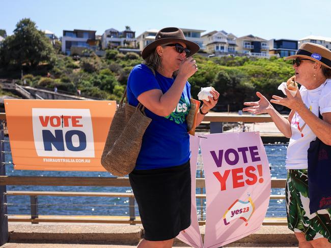 SYDNEY, AUSTRALIA - OCTOBER 14: Two woman chat and eat a democratic sausage, out the front of Clovelly Surf Life Saving Club polling centre on October 14, 2023 in Sydney, Australia. A referendum for Australians to decide on an indigenous voice to parliament was held on October 14, 2023 and compelled all Australians to vote by law. Early voting began on October 2, and activity has been intensifying in both the YES and NO camps, with multiple polls showing the YES campaign headed for defeat nationally. Australia requires a "double majority" of both the states and voters across the country to trigger constitutional changes, with most referendums in the past having failed. (Photo by Jenny Evans/Getty Images)