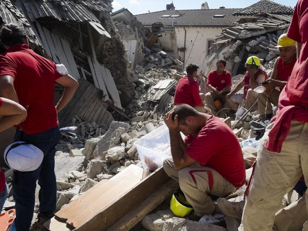 Rescuers pause in Amatrice, central Italy, where a 6.1 earthquake struck just after 3:30 a.m., Wednesday, Aug. 24, 2016. The quake was felt across a broad section of central Italy, including the capital Rome where people in homes in the historic center felt a long swaying followed by aftershocks. (AP Photo/Emilio Fraile)