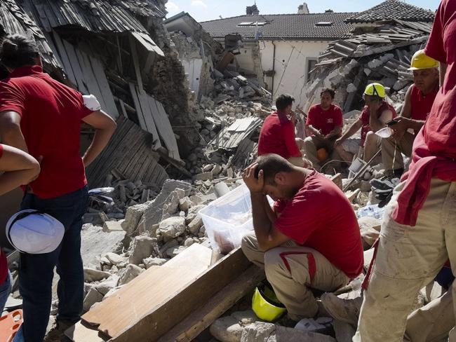 Rescuers pause in Amatrice, central Italy, where a 6.1 earthquake struck just after 3:30 a.m., Wednesday, Aug. 24, 2016. The quake was felt across a broad section of central Italy, including the capital Rome where people in homes in the historic center felt a long swaying followed by aftershocks. (AP Photo/Emilio Fraile)