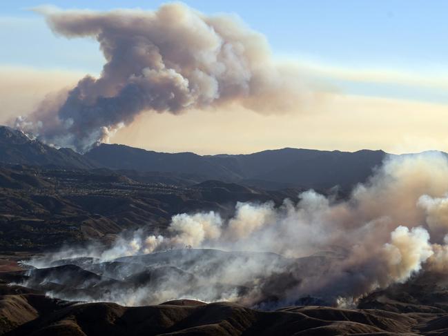 TOPSHOT - In this aerial view taken from a helicopter, the Kenneth fire (below) approaches homes while the back side of the Palisade fire (above) continues to burn Los Angeles county, California on January 9, 2025. Massive wildfires that engulfed whole neighborhoods and displaced thousands in Los Angeles remained totally uncontained January 9, 2025, authorities said, as US National Guard soldiers readied to hit the streets to help quell disorder. Swaths of the United States' second-largest city lay in ruins, with smoke blanketing the sky and an acrid smell pervading almost every building. (Photo by JOSH EDELSON / AFP)