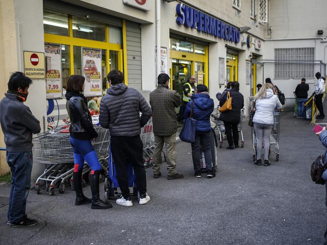 An Australian woman living in Italy has revealed people needing groceries can only enter supermarkets two at a time. Seen, people queuing outside a supermarket in Rome. Picture: Cecilia Fabiano/LaPresse via AP