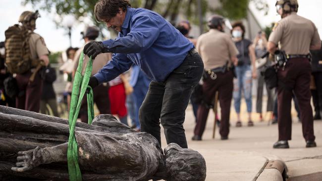 A protester with a statue of Christopher Columbus at the State Capitol in St Paul, Minnesota. Picture: AFP