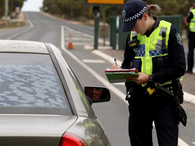 South Australian Police stopping vehicles near the SA border 5kms east of Pinnaroo, South Australia, Tuesday, March 24, 2020. (AAP Image/Kelly Barnes) South Australia has closed it borders and people must go into 14 day isolation due to the COVID-19 virus. NO ARCHIVING