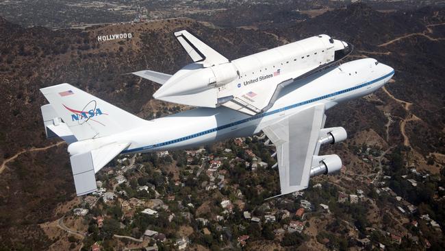 NASA image of space shuttle Endeavour on a modified Boeing 747 carrier aircraft flying over Los Angeles in 2012. It’s a far cheaper and more efficient way of launching space vehicles.