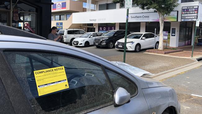 The dumped car takes up a parking spot on the busy City Rd in Beenleigh.