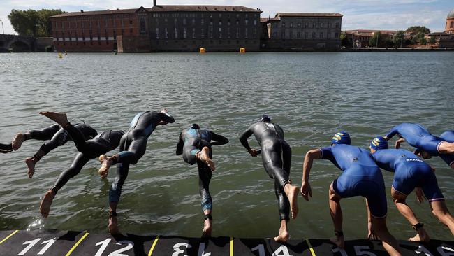 Triathletes dive into the Garonne river as they compete in the men's Supertri triathlon in Toulouse, south-western France, on October 6, 2024. (Photo by Valentine CHAPUIS / AFP)