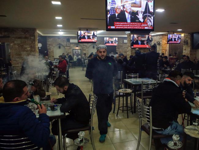 Palestinians sit in a cafe in the West Bank city of Ramallah watch Donald trump’s speech. Picture: AFP/Abbas Momani