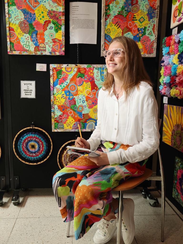 Local artist Hayley Stanich in front of some her work on display in Robina Hospital as part of Artbeat. Art Beat is a mental health initiative using painting as therapy. Picture Glenn Hampson