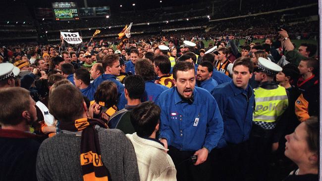 Security guards had their work cutout as fans invaded the ground 08/1996. The crowd invades the field after Jason Dunstall kicked his 100th goal. Melbourne v Hawthorn. 100 goals.