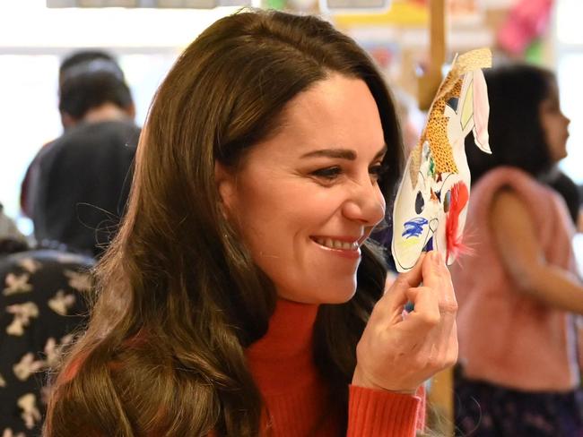 Britain's Catherine, Princess of Wales holds a mask to her face as she interacts with children during her visit to Foxcubs Nursery. Picture: AFP