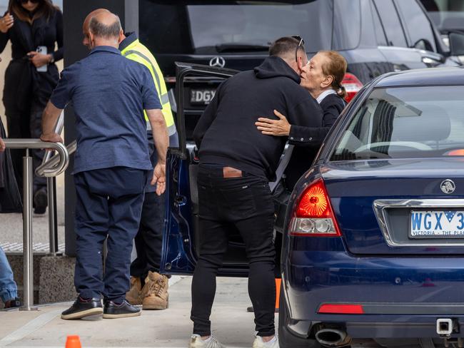 Mourners embrace outside the service.