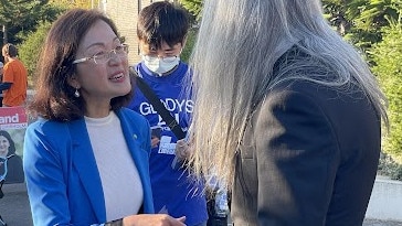 Liberal Chisholm MP Gladys Liu greets voters in the queue at Pinewood Primary School in Mount Waverley in the final hours of voting at the 2022 federal election on May 21. Picture: Kiel Egging.