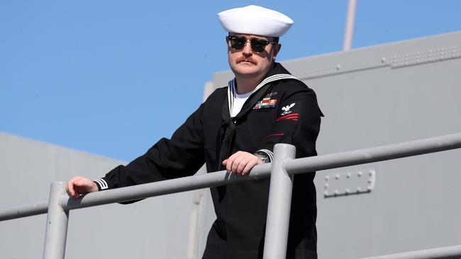 An officer looks out as the USS America comes into port. Picture: Liam Kidston