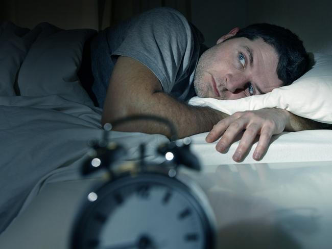 Gold Coast Bulletin - Good health guide - OCtober 2017 - young man in bed with eyes wide opened suffering insomnia , stress and sleep disorder thinking about his problem