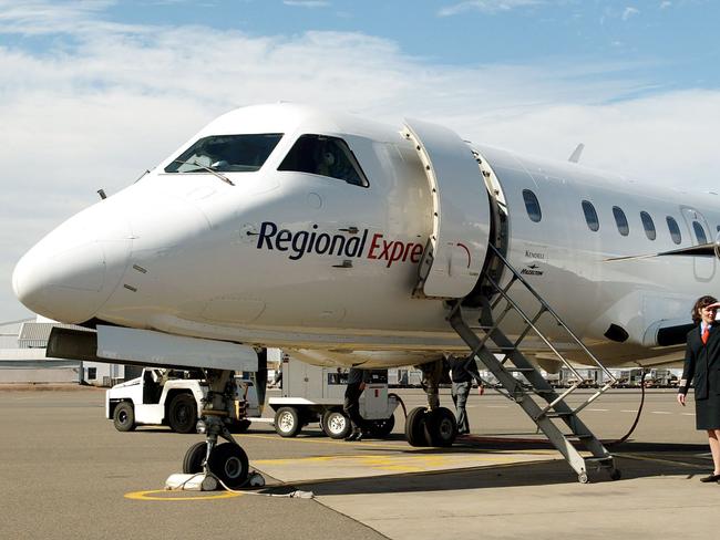 (FILES) A file photo taken on August 6, 2002, shows Captain Belinda Fleming standing in front of a Regional Express Airlines (REX) plane during the airline's launch at Sydney Airport. The regional Australian airline on March 20, 2017, grounded six planes from its fleet after a propeller fell off one of them as it approached Sydney airport. / AFP PHOTO / WILLIAM WEST