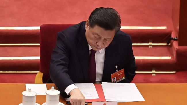 Xi Jinping pressing a button to join the National People’s Congress’s 2895-0 vote (with one abstention) to overhaul Hong Kong’s voting system on Thursday. Picture: Getty Images