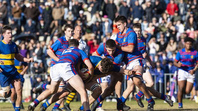 Downlands players (from left) Heath Lindenmayer, Jake Stephens and Rhys Chadburn attempt to stop Xander Jacobs of Grammar in O'Callaghan Cup on Grammar Downlands Day at Downlands College, Saturday, August 6, 2022. Picture: Kevin Farmer