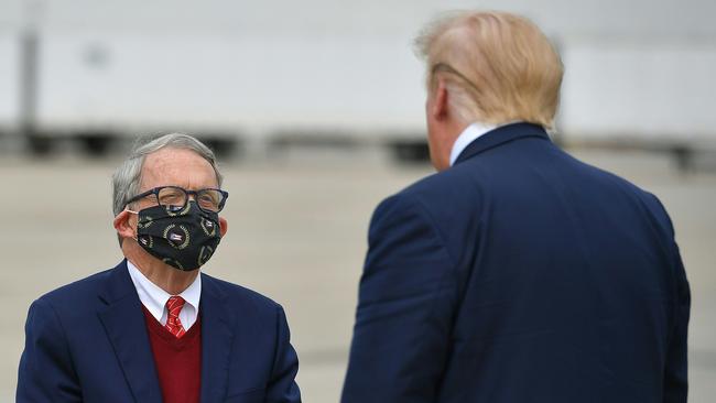 Ohio Governor Mike DeWine wears a mask while speaking with an unmasked US President Donald Trump at Rickenbacker International Airport in Columbus, Ohio on October 24. Picture: AFP