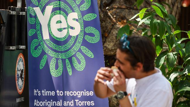 A supporter of the Yes campaign eats a sausage at an event in Darwin.