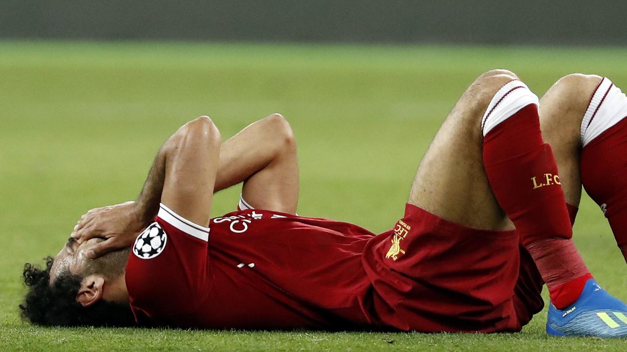 Liverpool's Mohamed Salah grimaces on the ground after injuring himself during the Champions League Final.