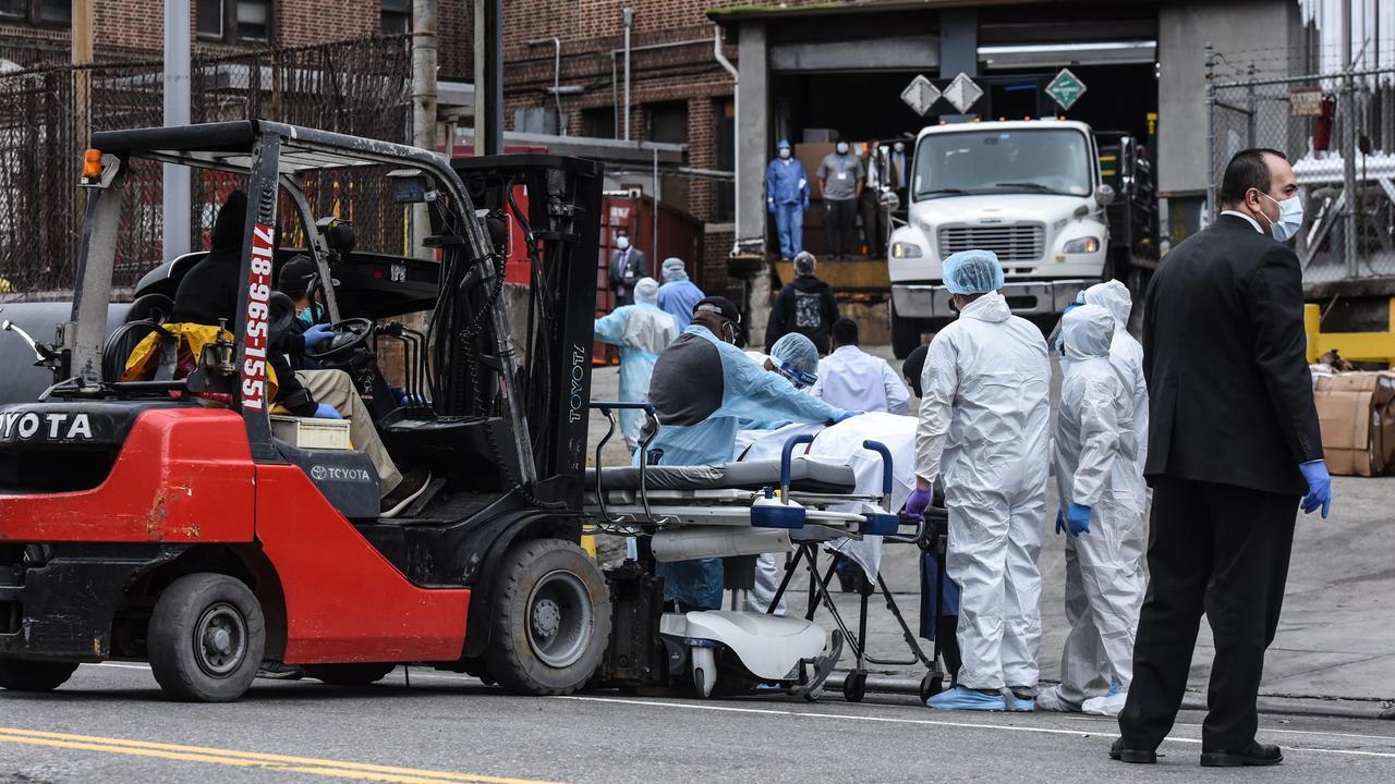 Medical workers remove a body from a refrigerated truck to put in a hearse outside of the Brooklyn Hospital on March 31. Picture: Stephanie Keith/Getty Images/AFP