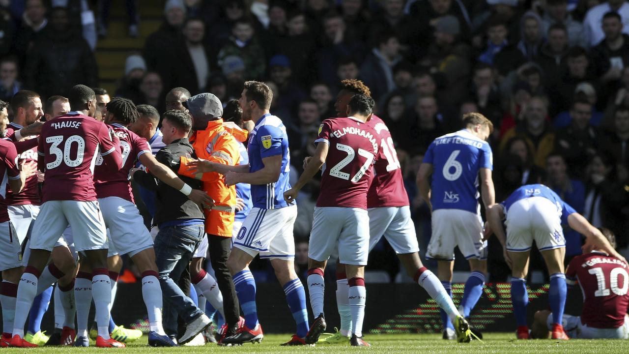 A fan is removed after attacking Aston Villa's Jack Grealish, right, on the pitch during the Sky Bet Championship soccer match at St Andrew's Trillion Trophy Stadium, Birmingham, England, Sunday March 10, 2019. (Nick Potts/PA via AP)