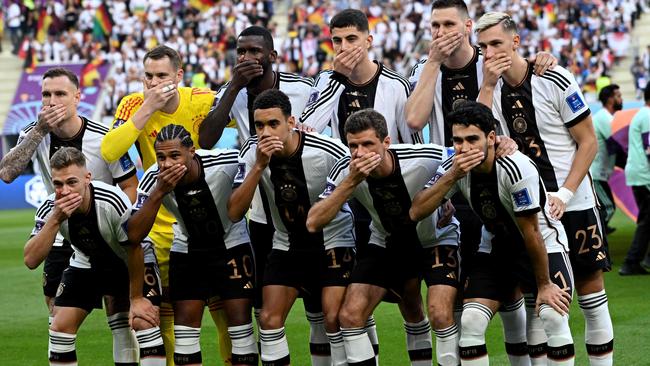 Germany players covered their mouths for the team photo before their opening match against Japan. Picture: AFP