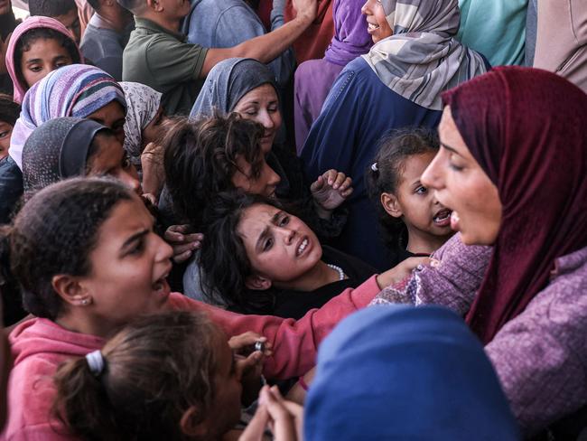 A woman argues with girls as people crowd outside a bakery as they queue for bread in Khan Yunis in the southern Gaza Strip. Picture: AFP