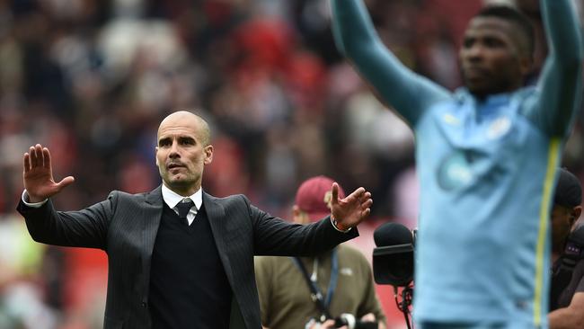 Manchester City's Spanish manager Pep Guardiola and his players celebrate.