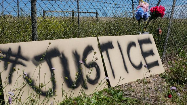 A sign and floral tributes placed at the site of the fatal crash. Picture: Jessica Ball.