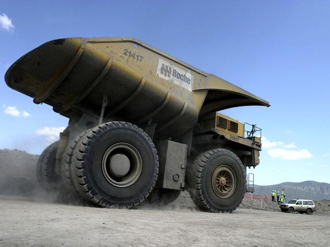 A large dump truck dwarfs a nearby vehicle as it drives at the Excel Coal Limited's Wambo Coal Mine in Hunter Valley, Australia. Australian exports rose to the second highest on record in October, narrowing the trade deficit more than expected, as miners including Portman Ltd. and BHP Billiton earned more from commodity shipments to China. Photographer: Michael Caronna/Bloomberg News.