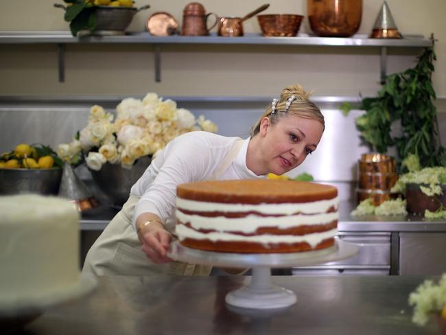 Owner of Violet Bakery Claire Ptak puts finishing touches to the wedding cake of Prince Harry and Meghan Markle in the kitchens of Buckingham Palace. Picture: AFP/Pool/Hannah Mckay