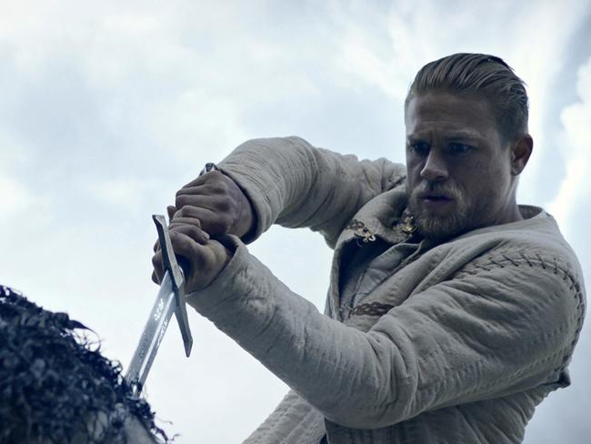 Hunnam pulls Excalibur from the stone in the rollicking new movie take on the Arthurian myth. Picture: Warner Bros Pictures