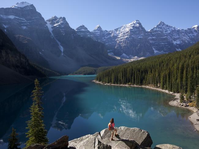 ESCAPE: FAQ Rockies, Alissa Jenkins -  Female backpacker standing on boulder admiring majestic view of Moraine Lake and Canadian Rockies. . Picture: iStock